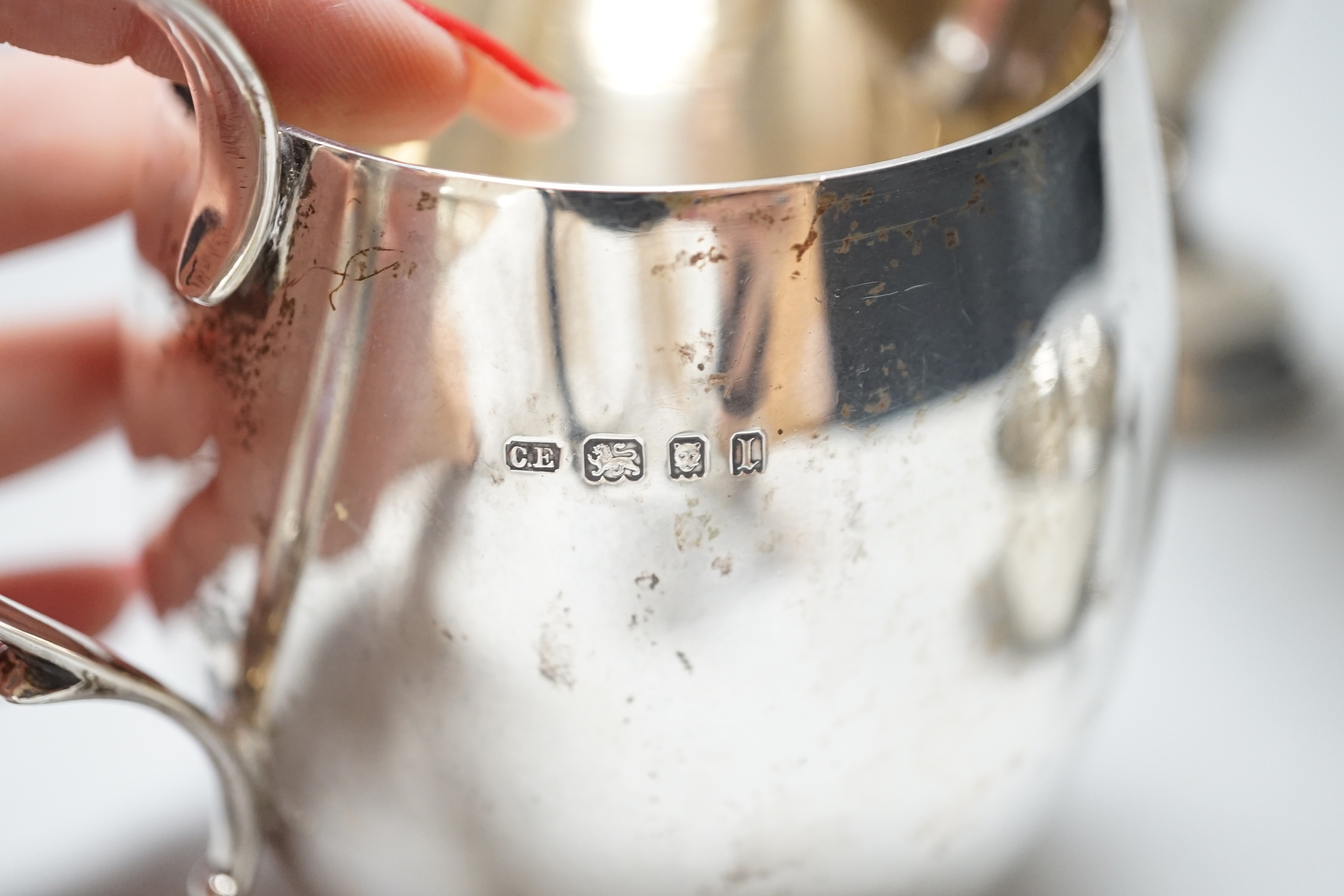 A George V silver cream jug, London 1926, 216 grams, a sugar bowl, Birmingham 1924, 107 grams and a spill vase with loaded base, Birmingham 1919, 20.5cm